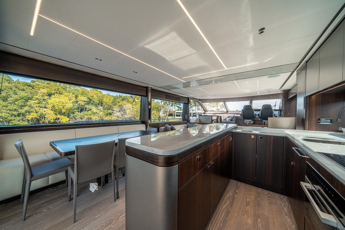 a kitchen with a bar and a table and chairs aboard 88 YACHT Yacht for Sale