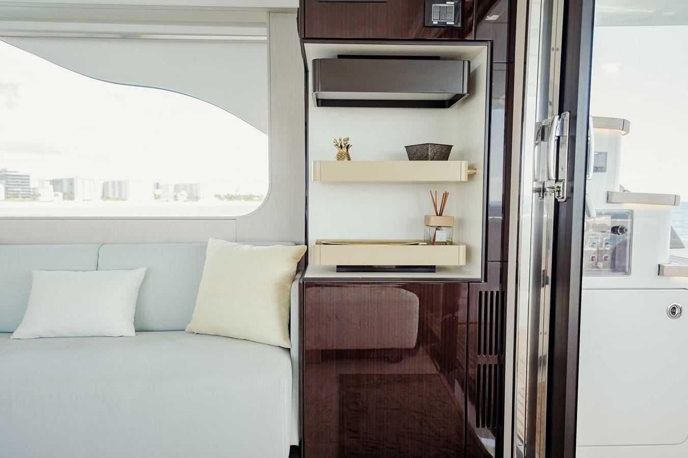 a room with a bed and a shelf with a window aboard TRANSCENDENCE Yacht for Sale