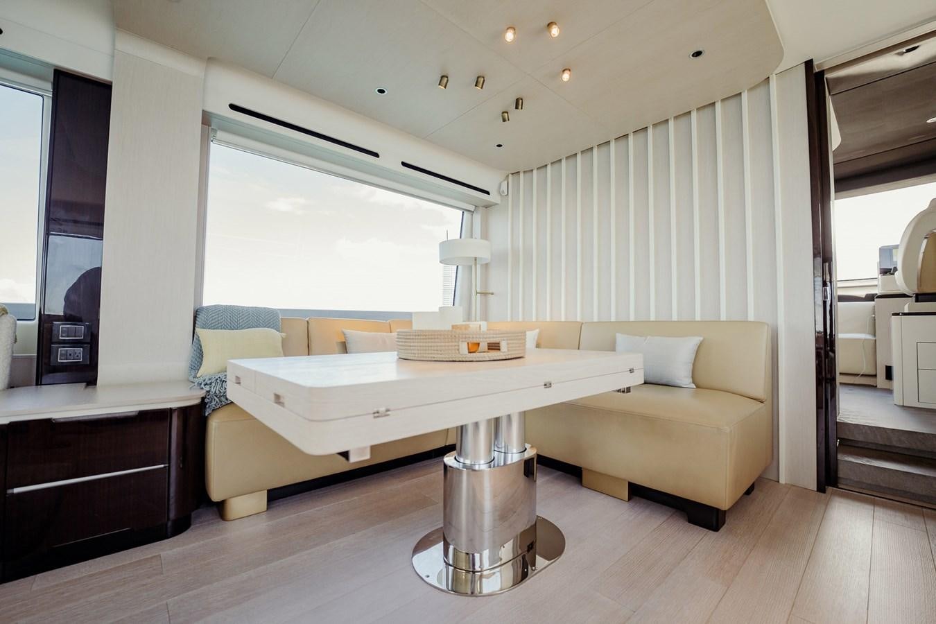 a living room with a table and couches aboard TRANSCENDENCE Yacht for Sale