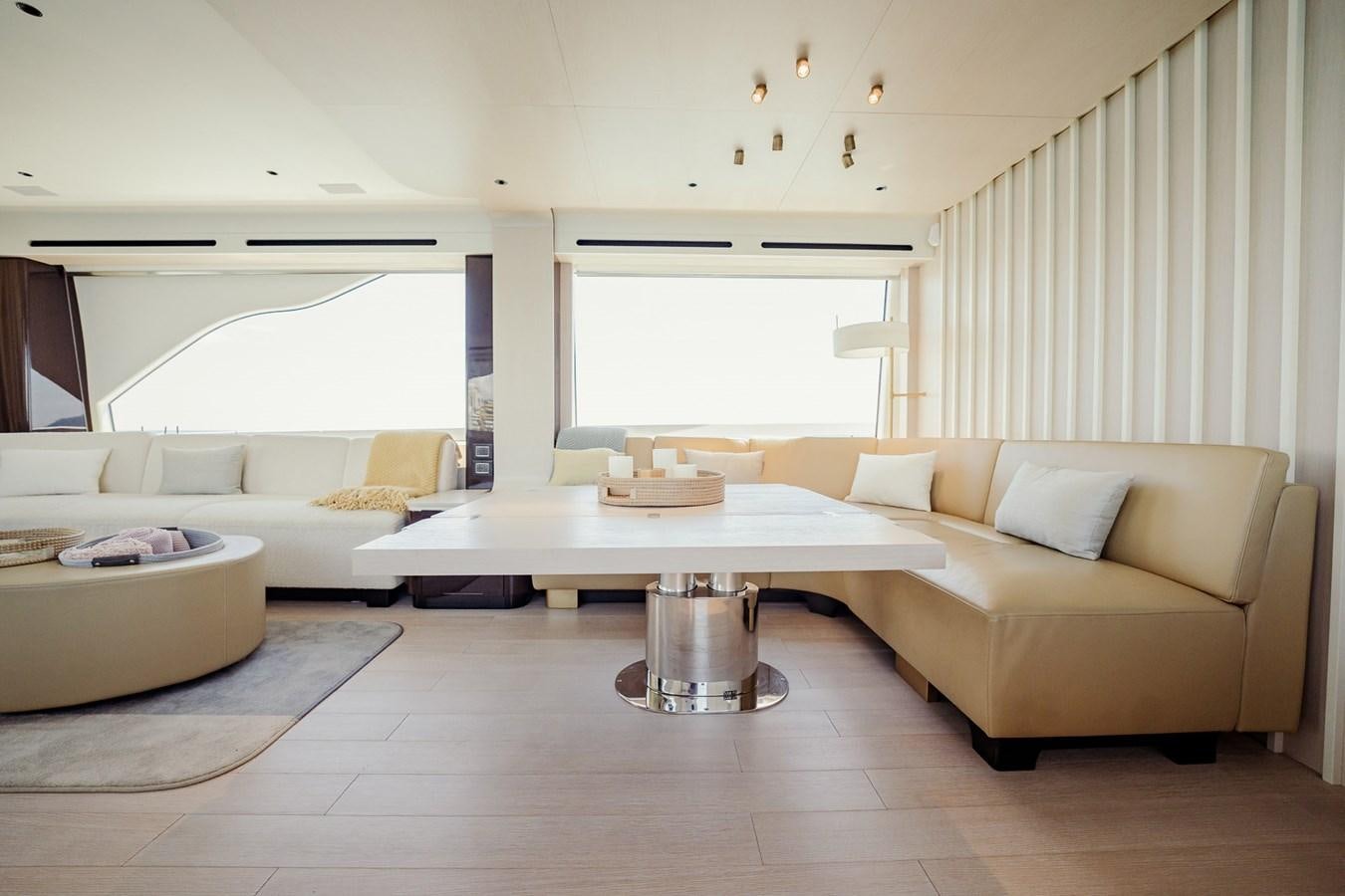 a living room with a table and couches aboard TRANSCENDENCE Yacht for Sale