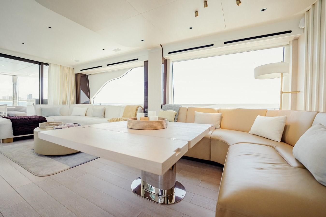 a living room with a table and couches aboard TRANSCENDENCE Yacht for Sale