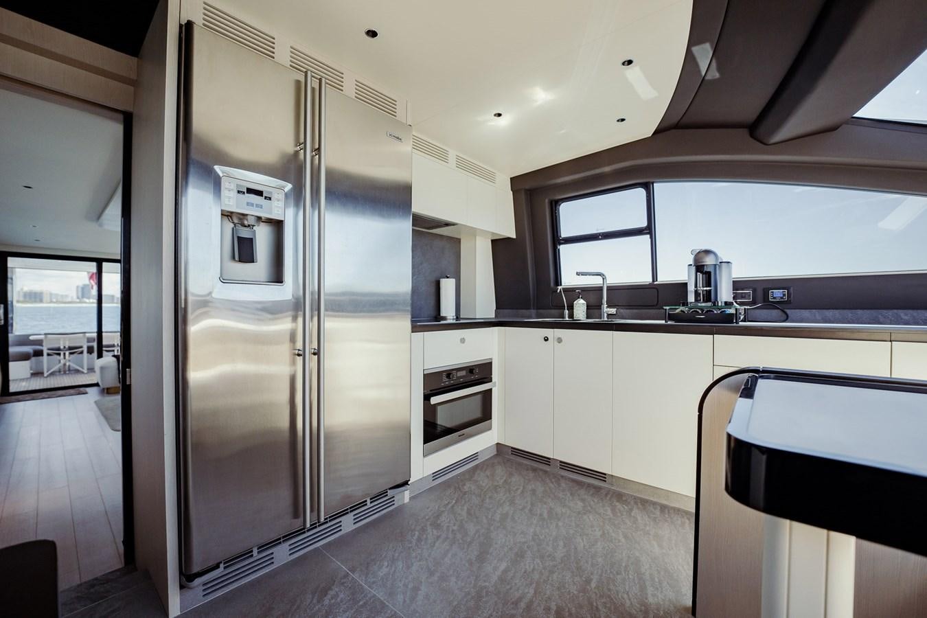 a large kitchen with a large refrigerator aboard TRANSCENDENCE Yacht for Sale