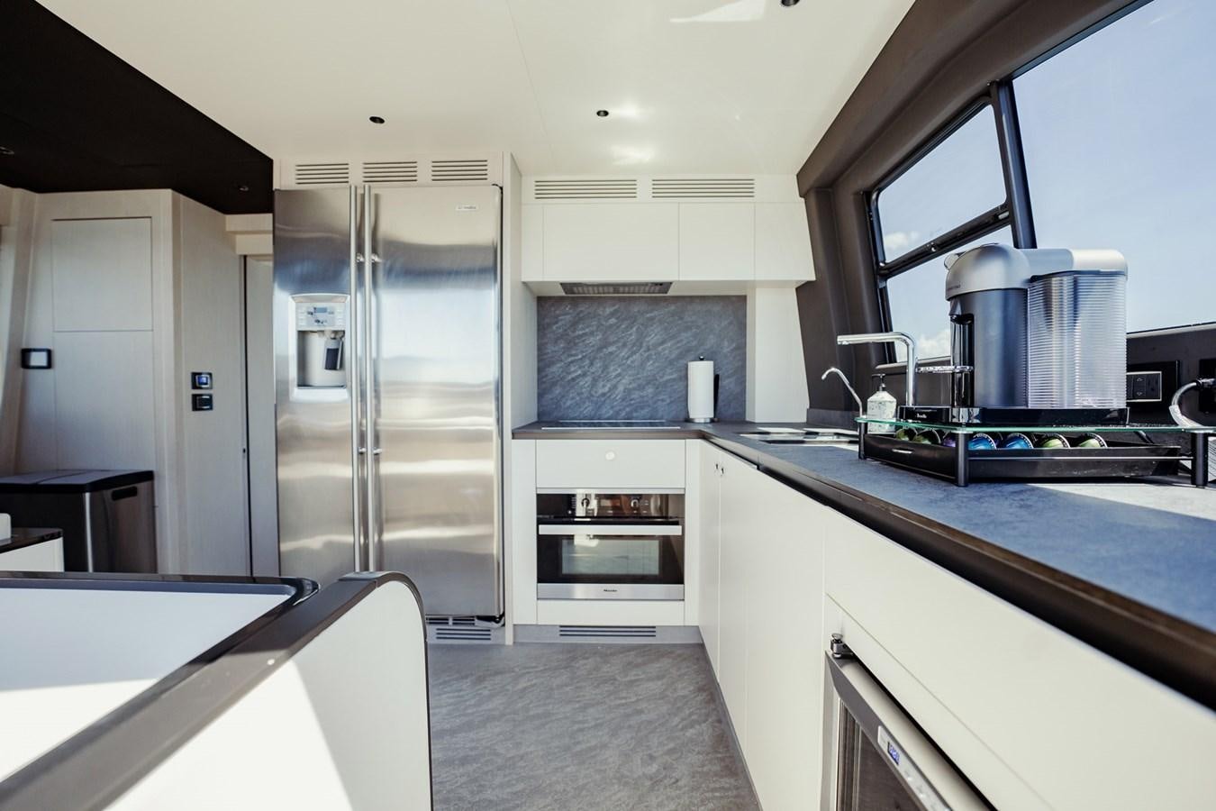a kitchen with a stainless steel refrigerator aboard TRANSCENDENCE Yacht for Sale