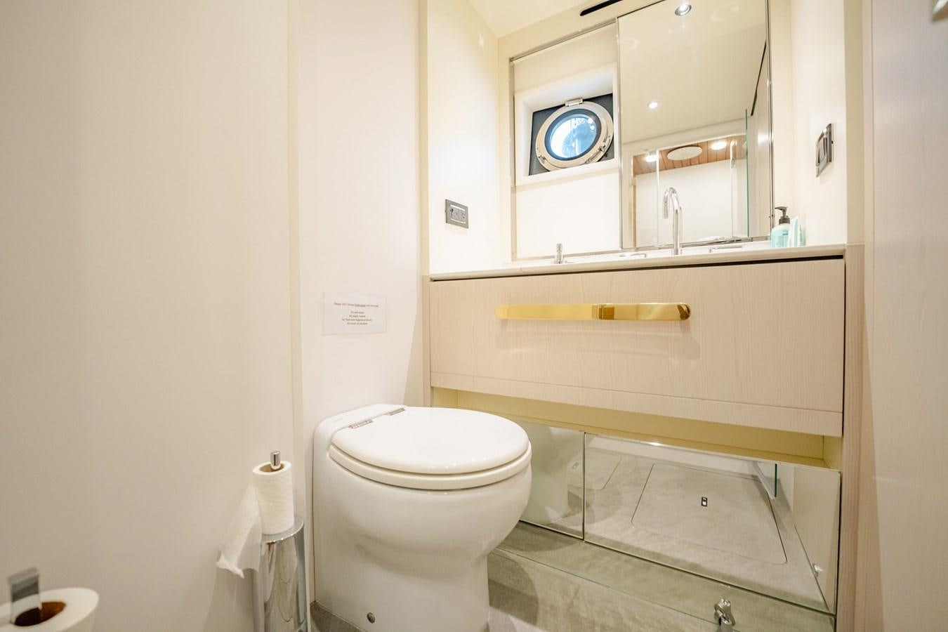 a bathroom with a toilet and a mirror aboard TRANSCENDENCE Yacht for Sale