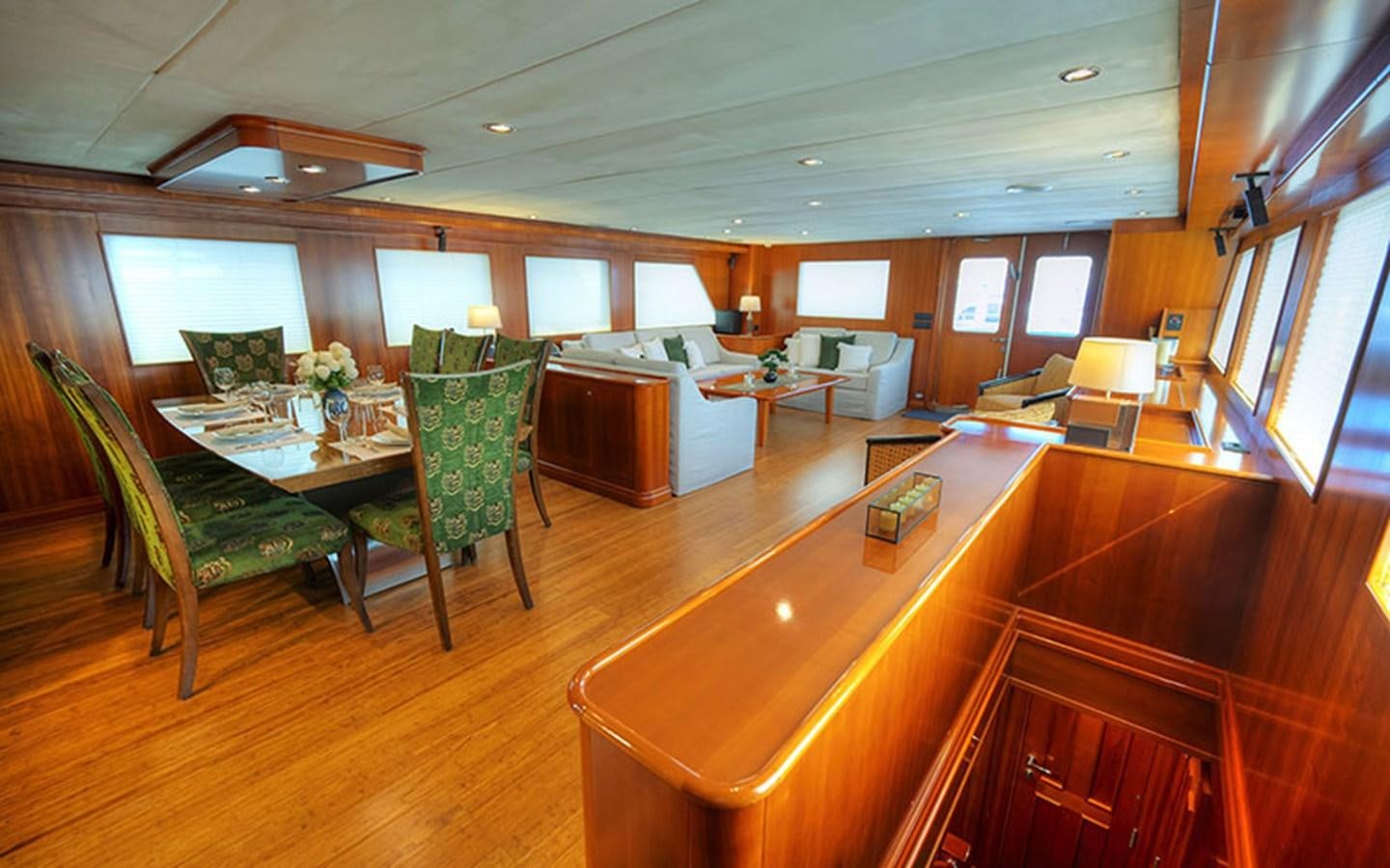 a room with a table chairs and a couch aboard VOYAGER Yacht for Sale