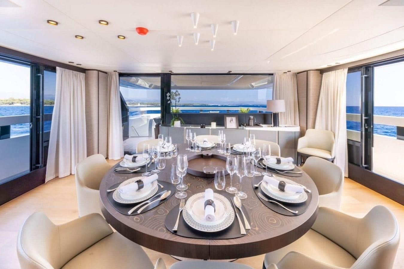 a dining table with plates and glasses aboard MY UILIA Yacht for Sale