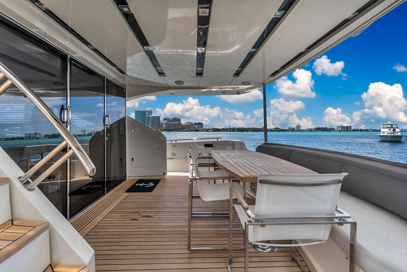 a deck with chairs and a body of water in the background aboard GREYT ESCAPE Yacht for Sale