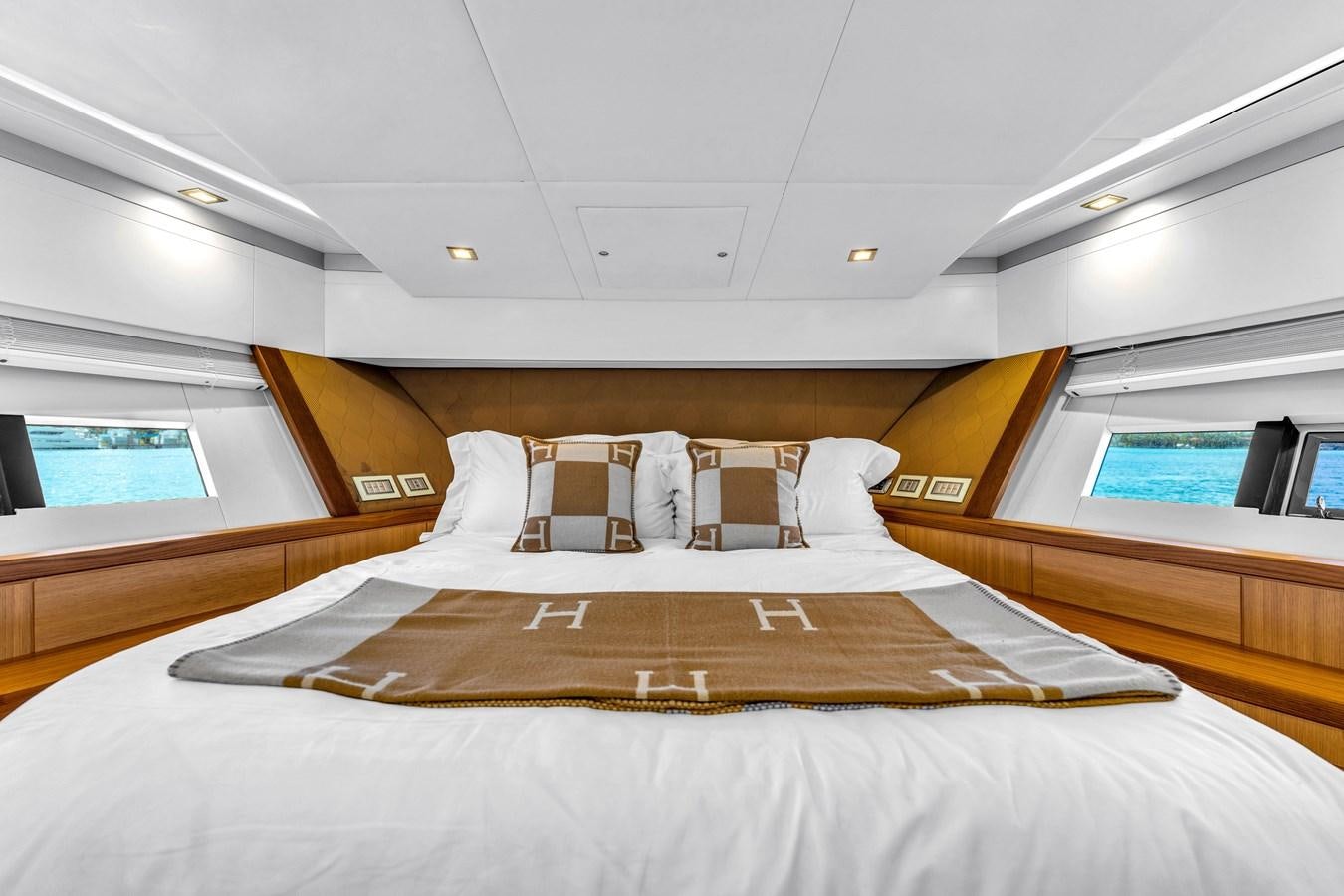 a bed with a white sheet and a brown bed spread aboard GREYT ESCAPE Yacht for Sale