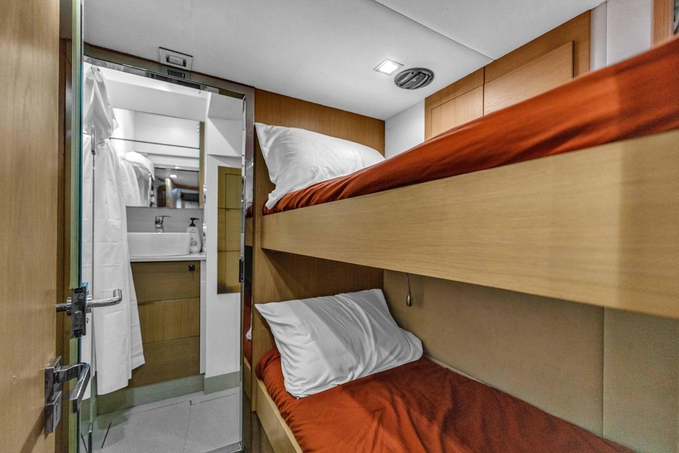 a bed with a mirror and a sink in a room aboard GREYT ESCAPE Yacht for Sale