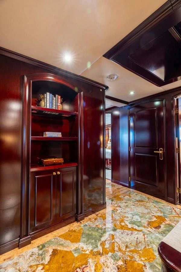 a room with a cabinet and a shelf with books on it aboard MISS CHRISTINE Yacht for Sale