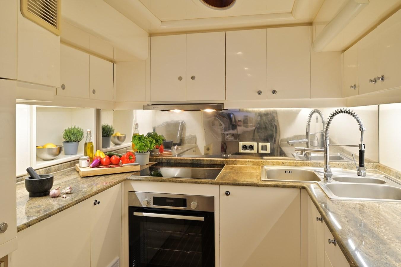 a kitchen with white cabinets aboard CLARITY Yacht for Sale