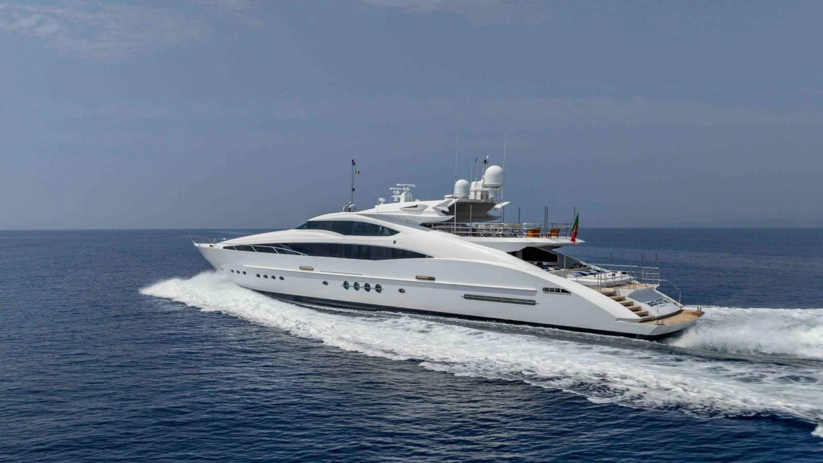 A sleek, modern yacht cruises swiftly across open waters under a clear sky. aboard PALMER JOHNSON 150 Yacht for Sale