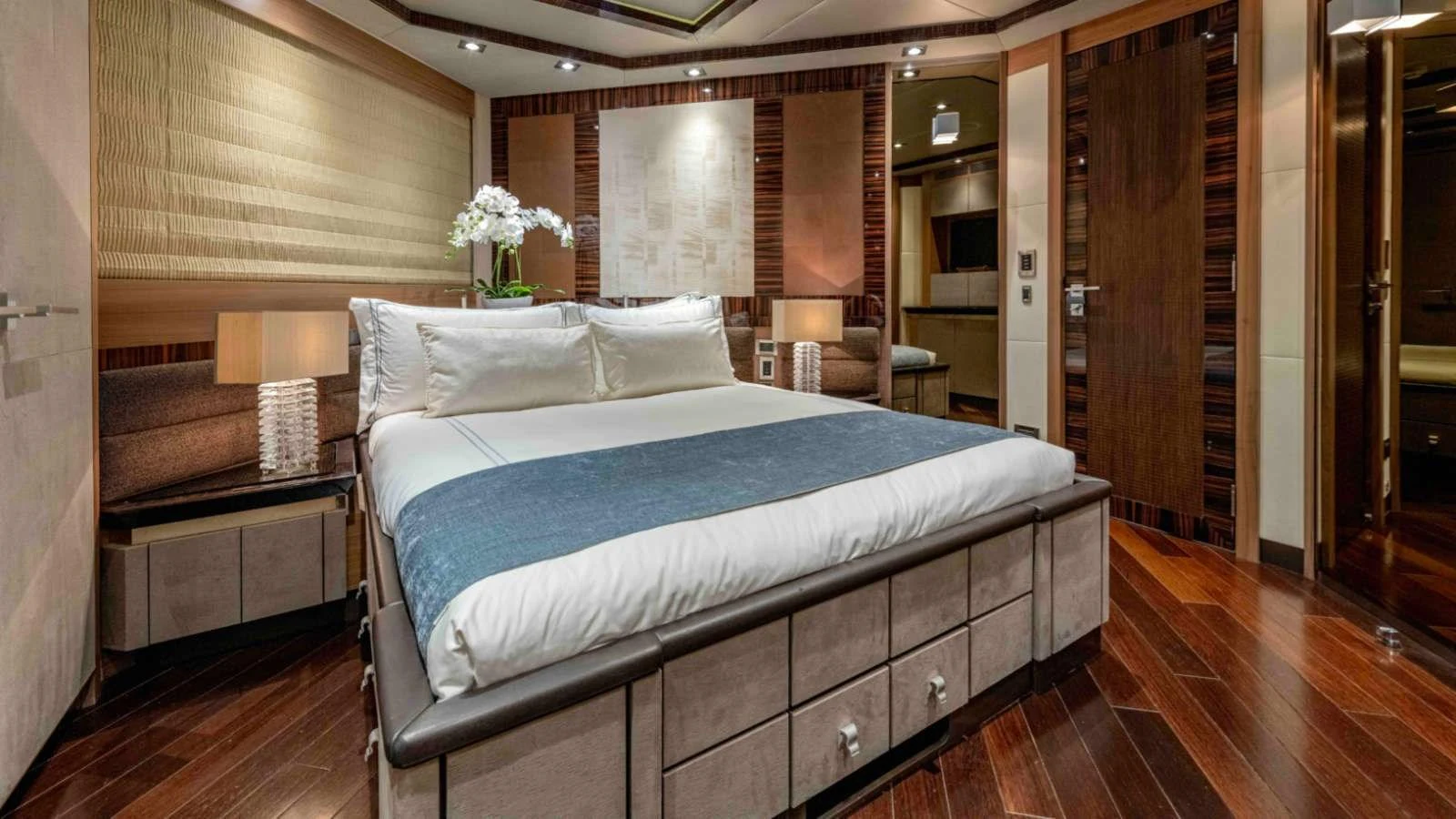 The stateroom features a luxurious bed with elegant decor and warm lighting. aboard PALMER JOHNSON 150 Yacht for Sale
