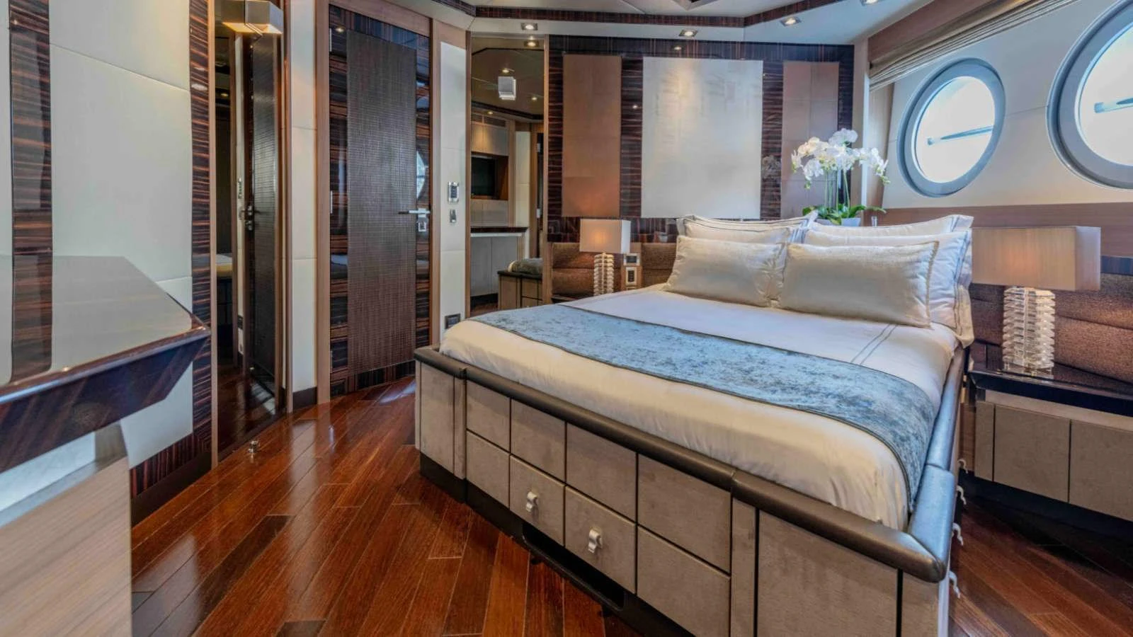 The master stateroom features a luxurious bed with elegant decor and ample natural light from the portholes. aboard PALMER JOHNSON 150 Yacht for Sale