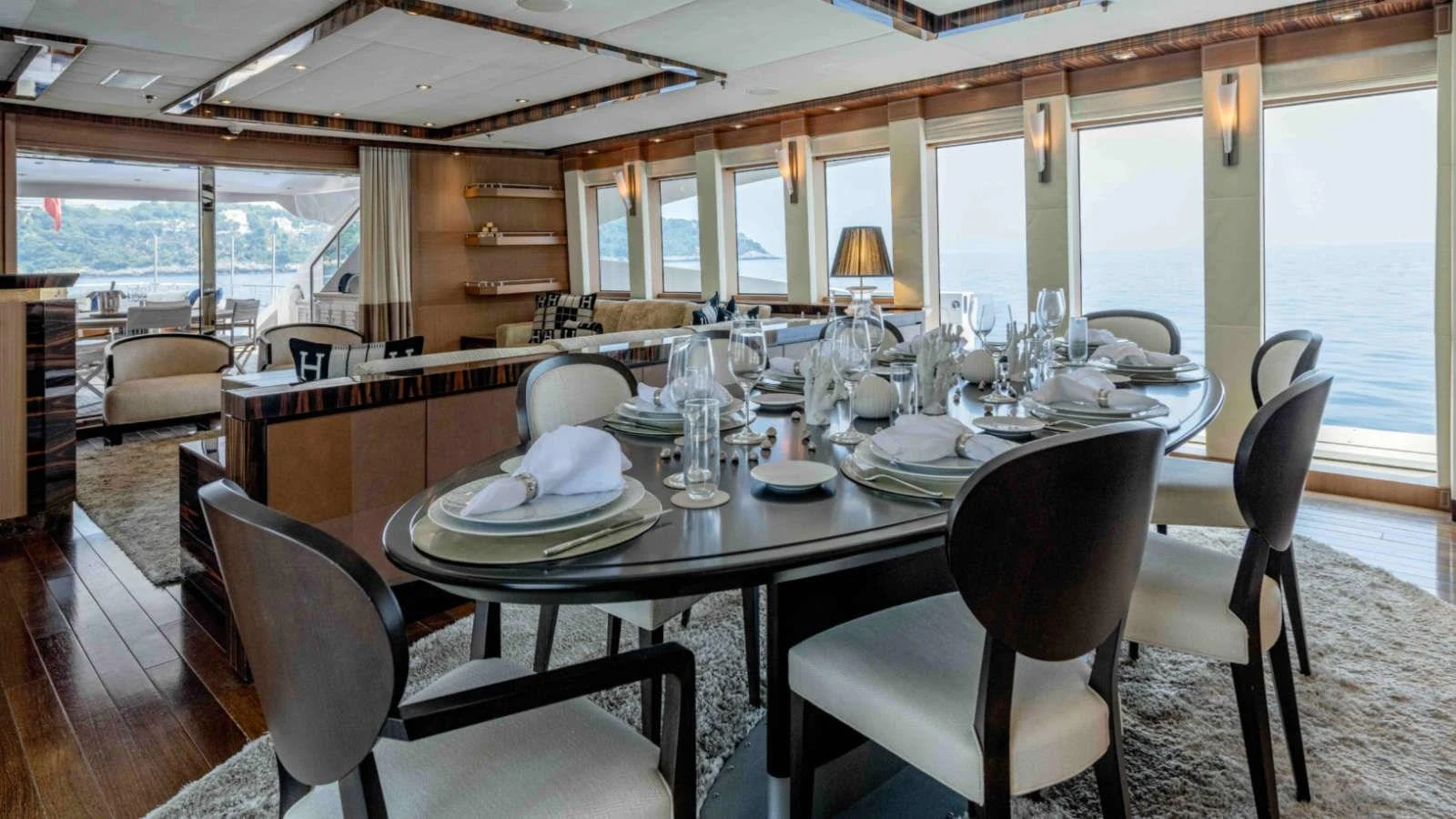 The yacht's dining area features an elegant table set for a fine dining experience with panoramic ocean views. aboard PALMER JOHNSON 150 Yacht for Sale