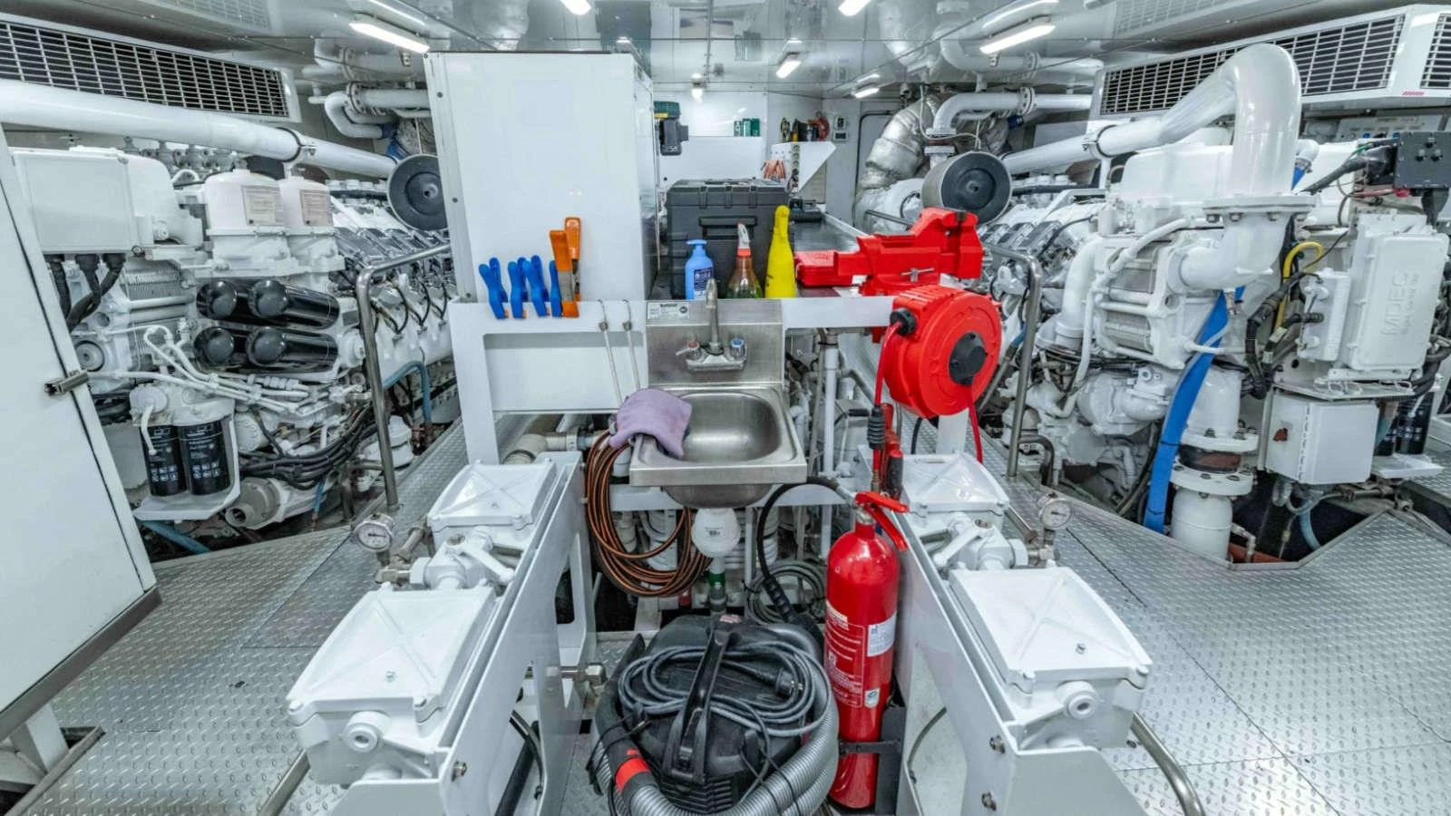 The image showcases a well-organized and meticulously maintained engine room with various equipment and tools. aboard PALMER JOHNSON 150 Yacht for Sale