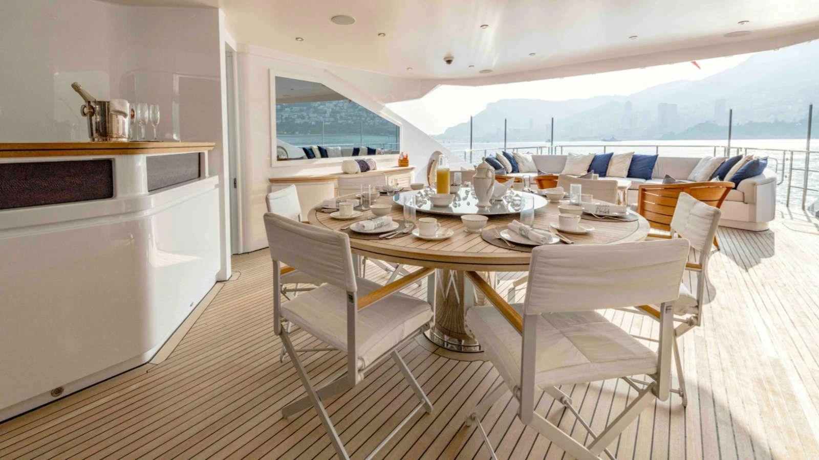 The aft deck features an elegant dining area with a round table and comfortable seating, offering stunning views. aboard PALMER JOHNSON 150 Yacht for Sale