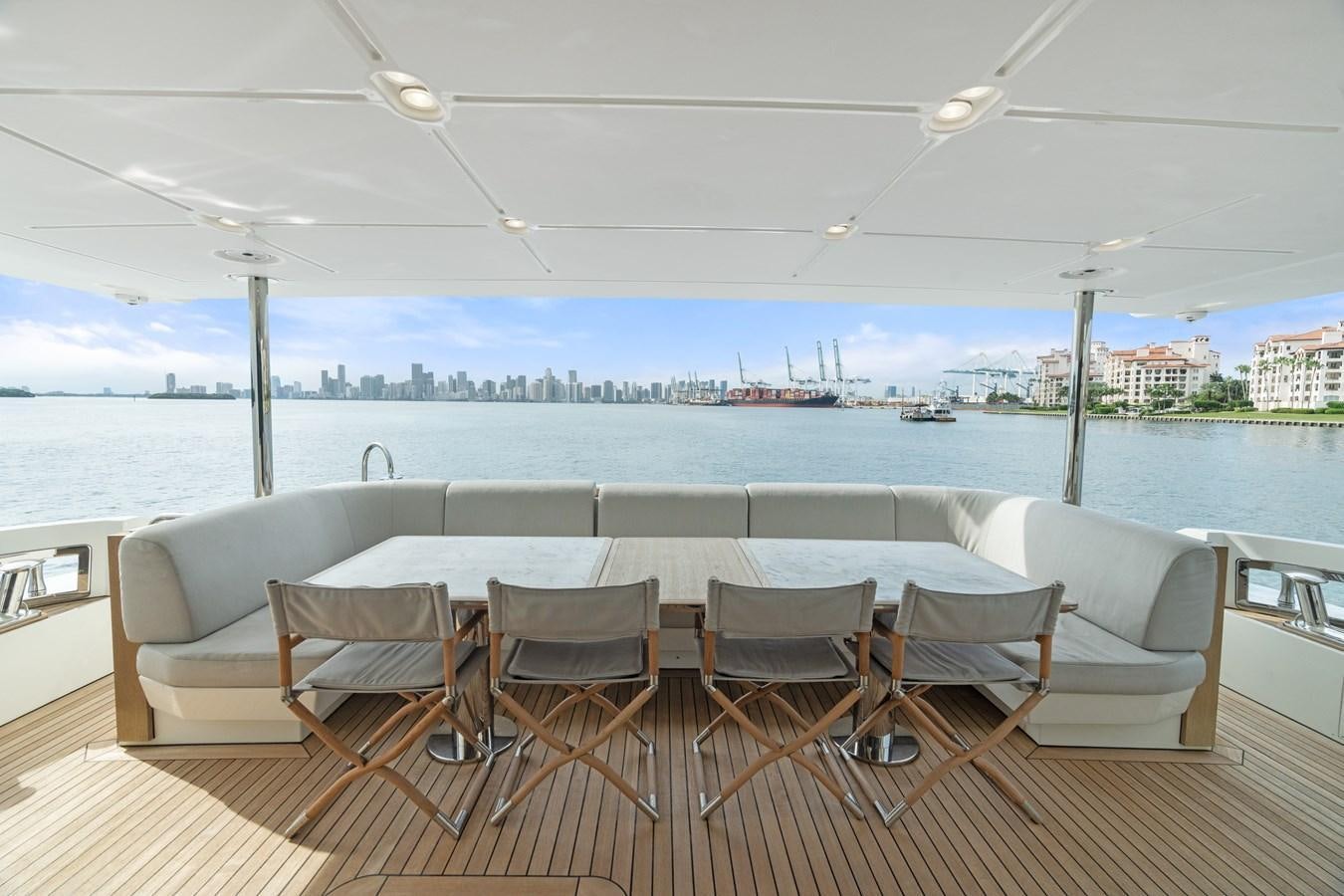 a table and chairs on a deck overlooking a body of water aboard Y Yacht for Sale