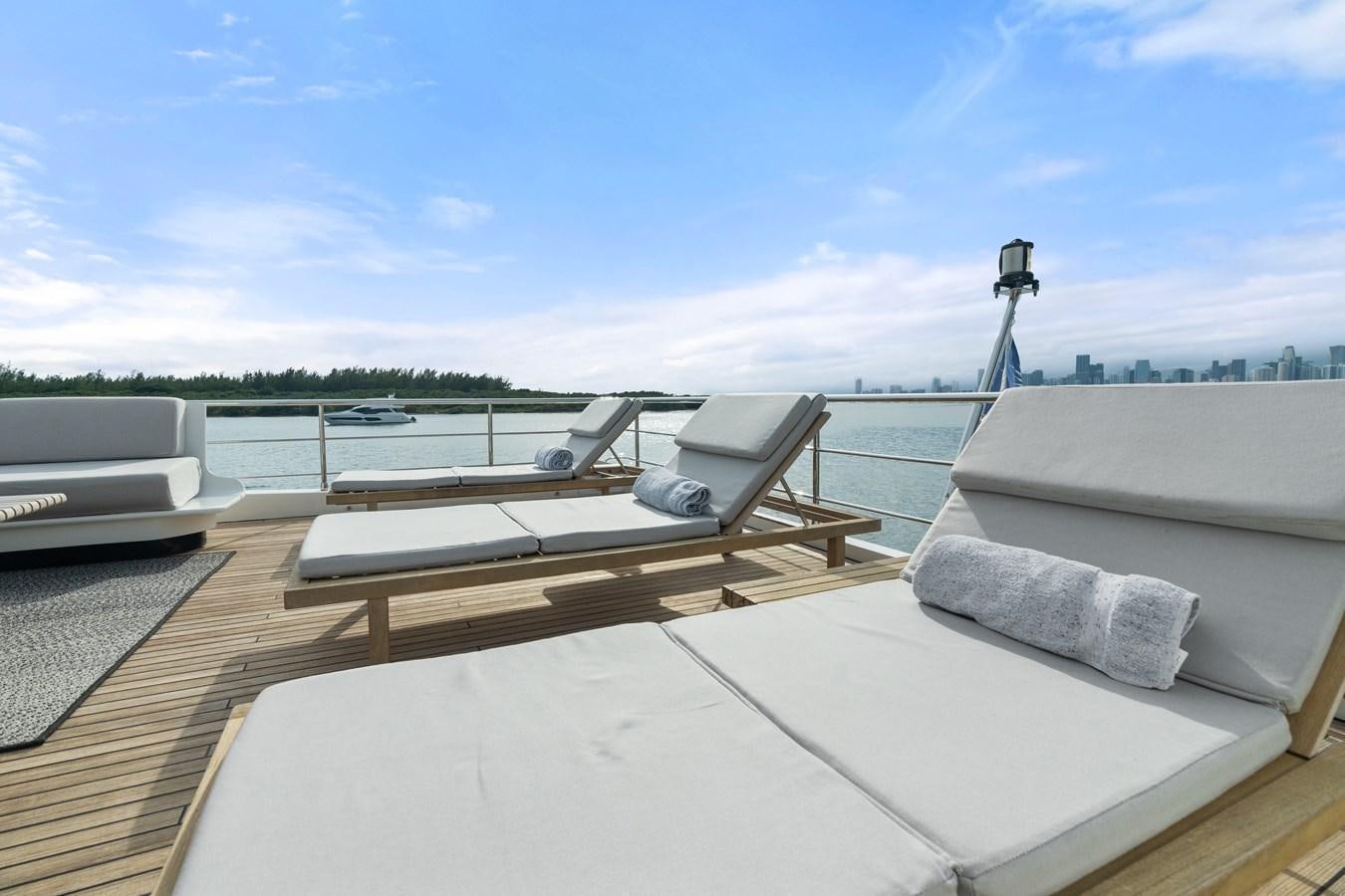 a deck with a view of a body of water and a boat on it aboard Y Yacht for Sale