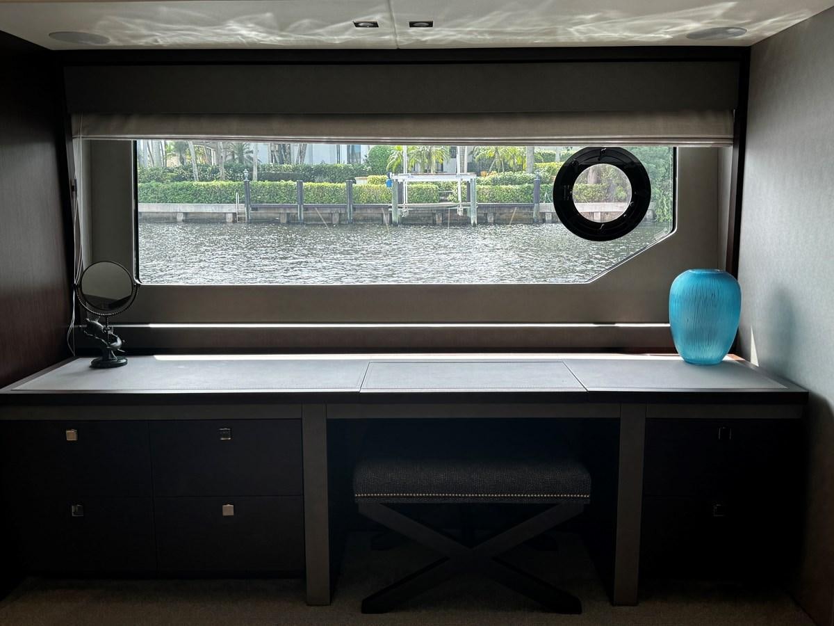 a room with a large window and a desk with a balloon and a window with a view of aboard JOURNEY Yacht for Sale