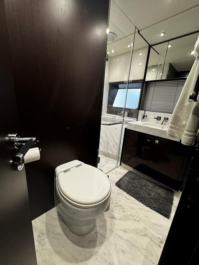 a bathroom with a toilet and a large mirror aboard JOURNEY Yacht for Sale