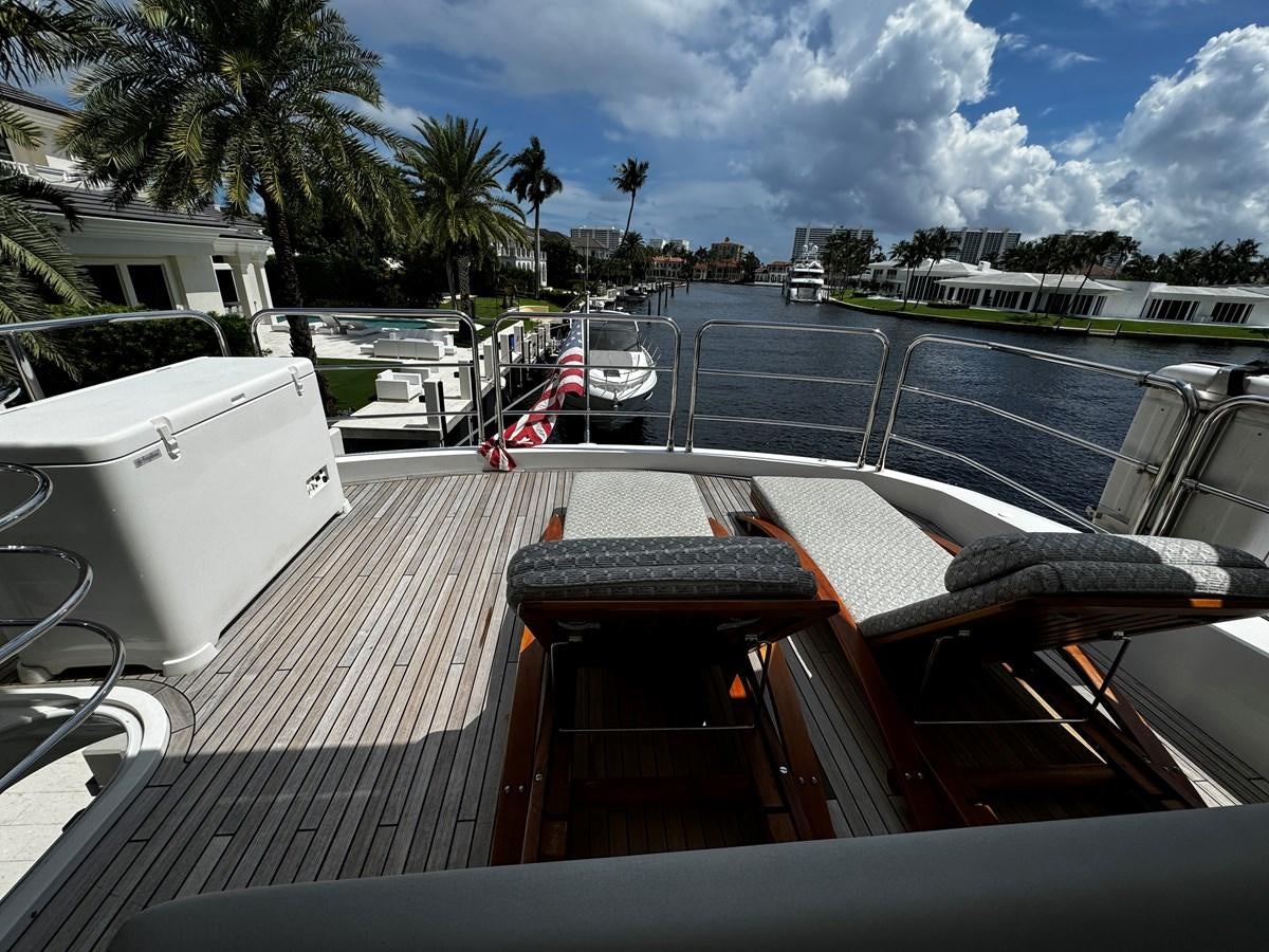 a deck with a railing and a railing with a building and trees in the background aboard JOURNEY Yacht for Sale