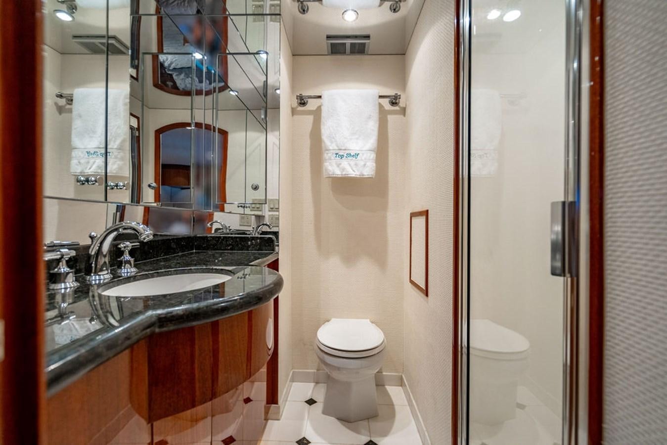 a bathroom with a sink toilet and a mirror aboard TOP SHELF Yacht for Sale