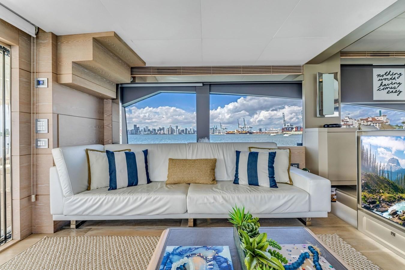 a living room with a large white couch and a large window aboard SEADUCTION Yacht for Sale