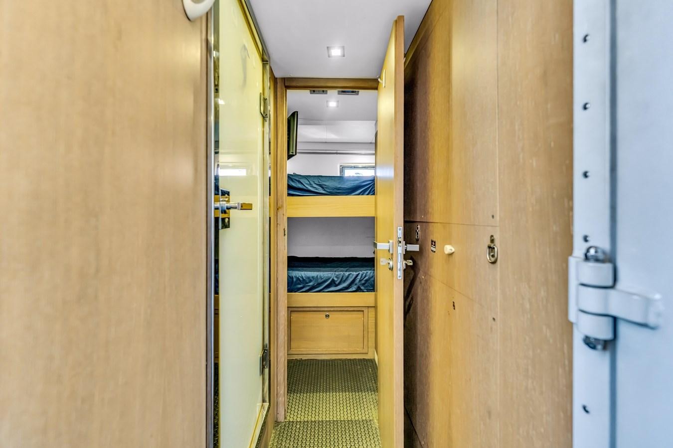 a hallway with a bed and bunk beds aboard SEADUCTION Yacht for Sale