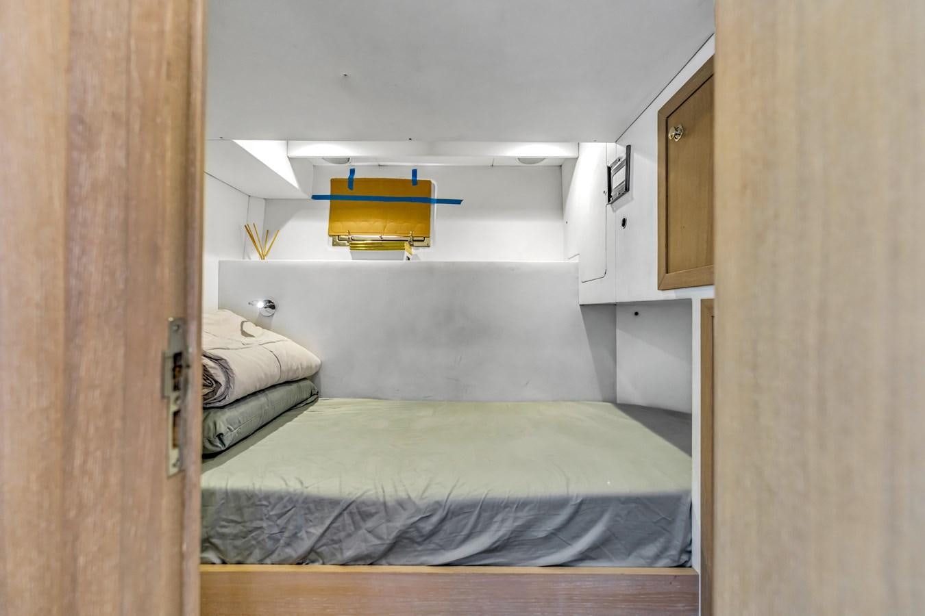 a small room with a bed and a shelf aboard SEADUCTION Yacht for Sale