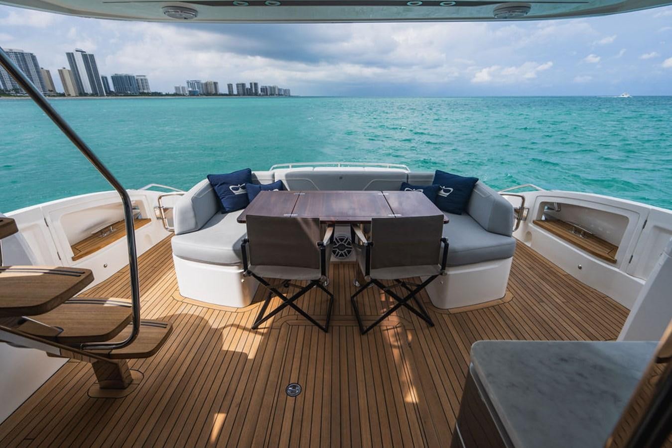 a deck with a table chairs and a large body of water aboard IMAGINE Yacht for Sale