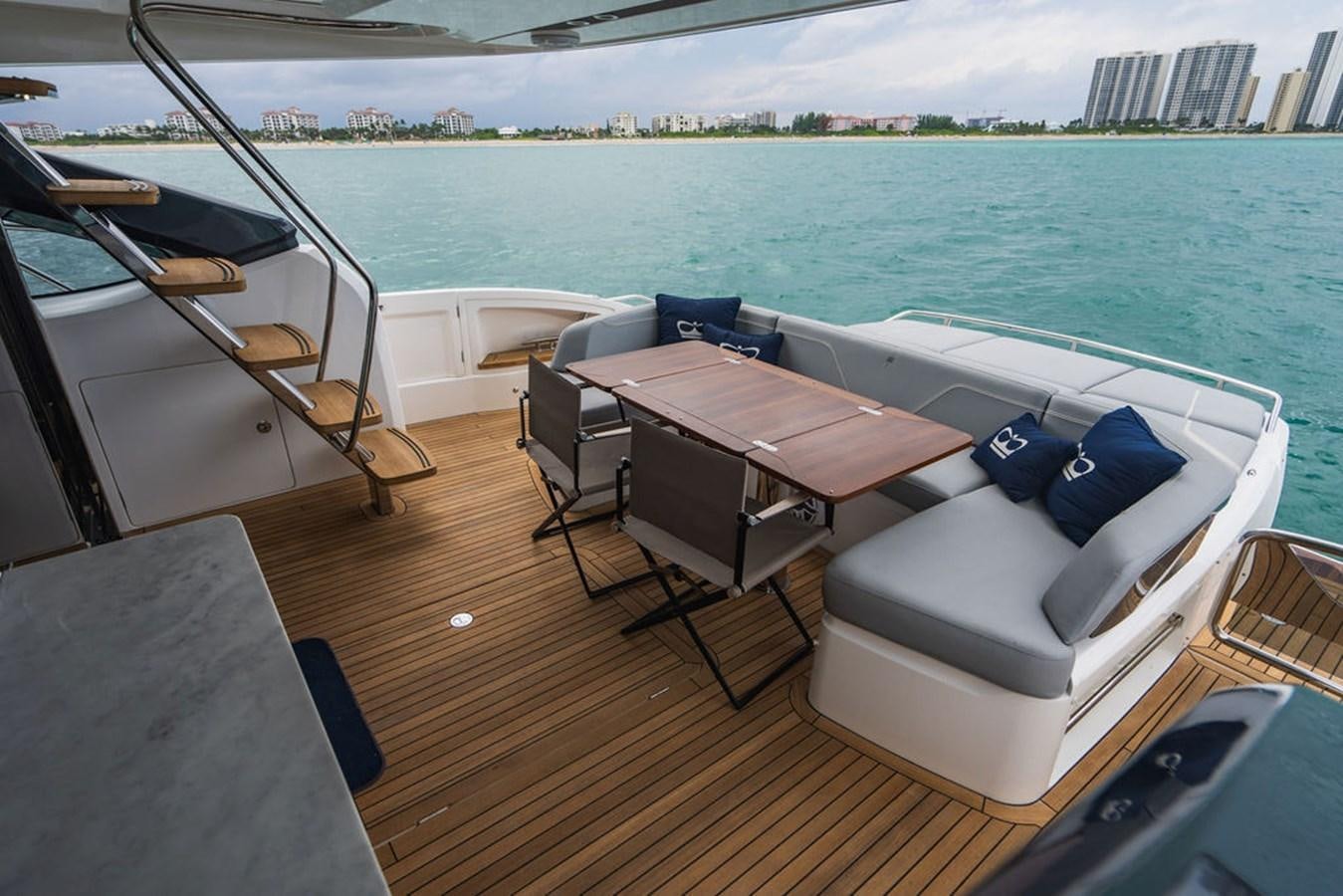 a deck with a table and chairs on it aboard IMAGINE Yacht for Sale