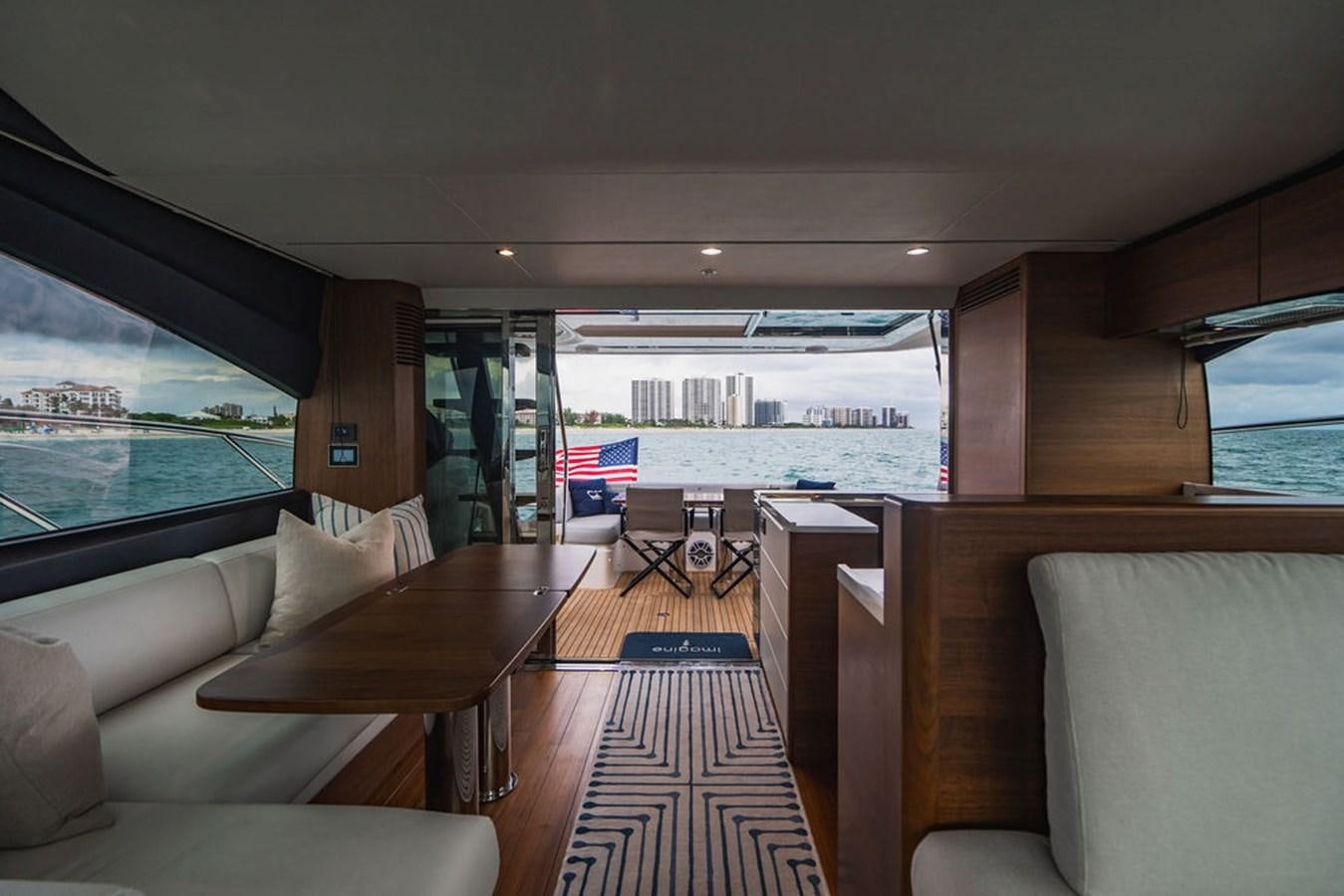 a living room with a wood table and couches aboard IMAGINE Yacht for Sale