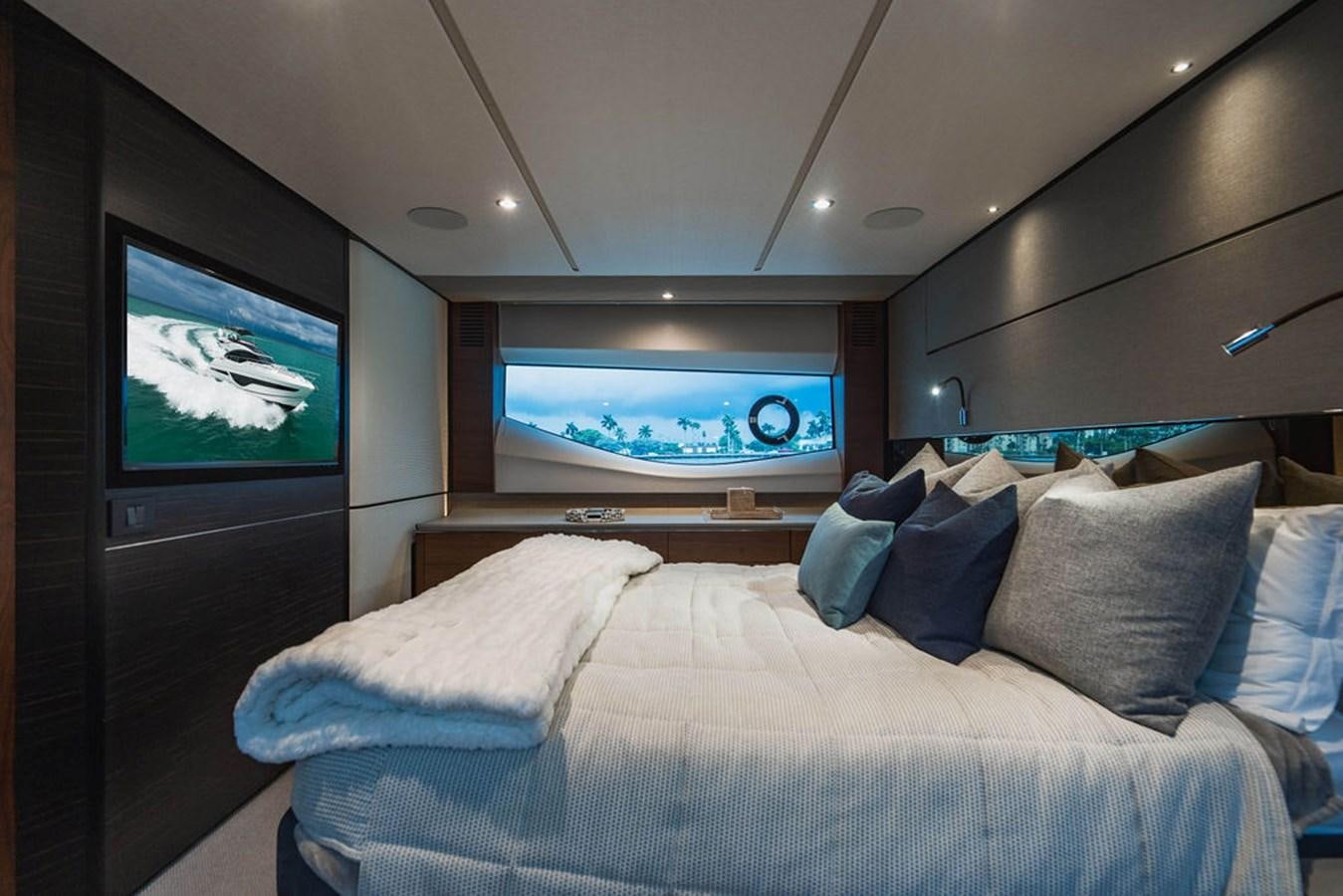 a bed with a television on the wall aboard IMAGINE Yacht for Sale