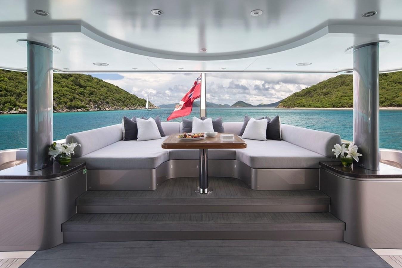 a room with a couch and a table and a flag aboard MUCHOS MAS Yacht for Sale
