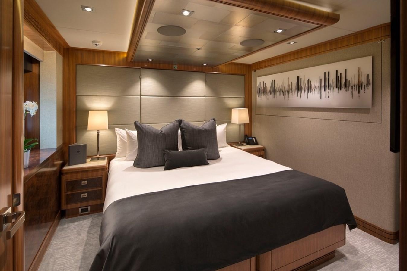a bed with a black and white bed spread aboard MUCHOS MAS Yacht for Sale