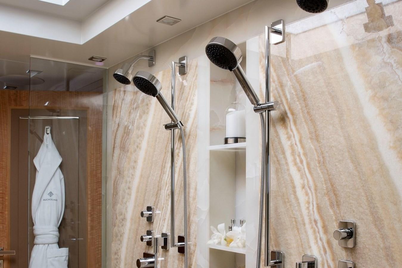 a bathroom with a robe on the wall aboard MUCHOS MAS Yacht for Sale