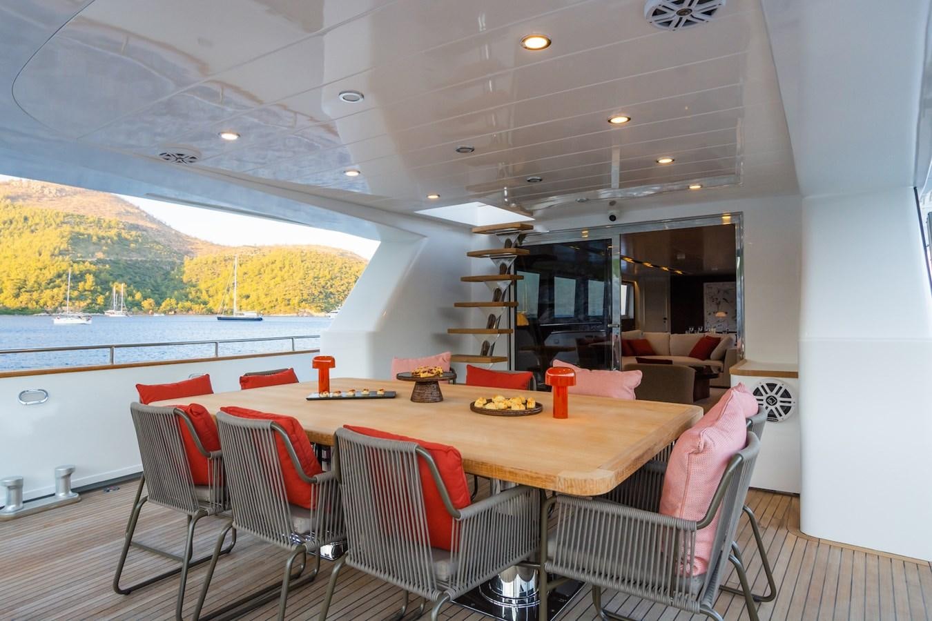 a room with a table chairs and a shelf with books on it aboard AXELLA Yacht for Sale