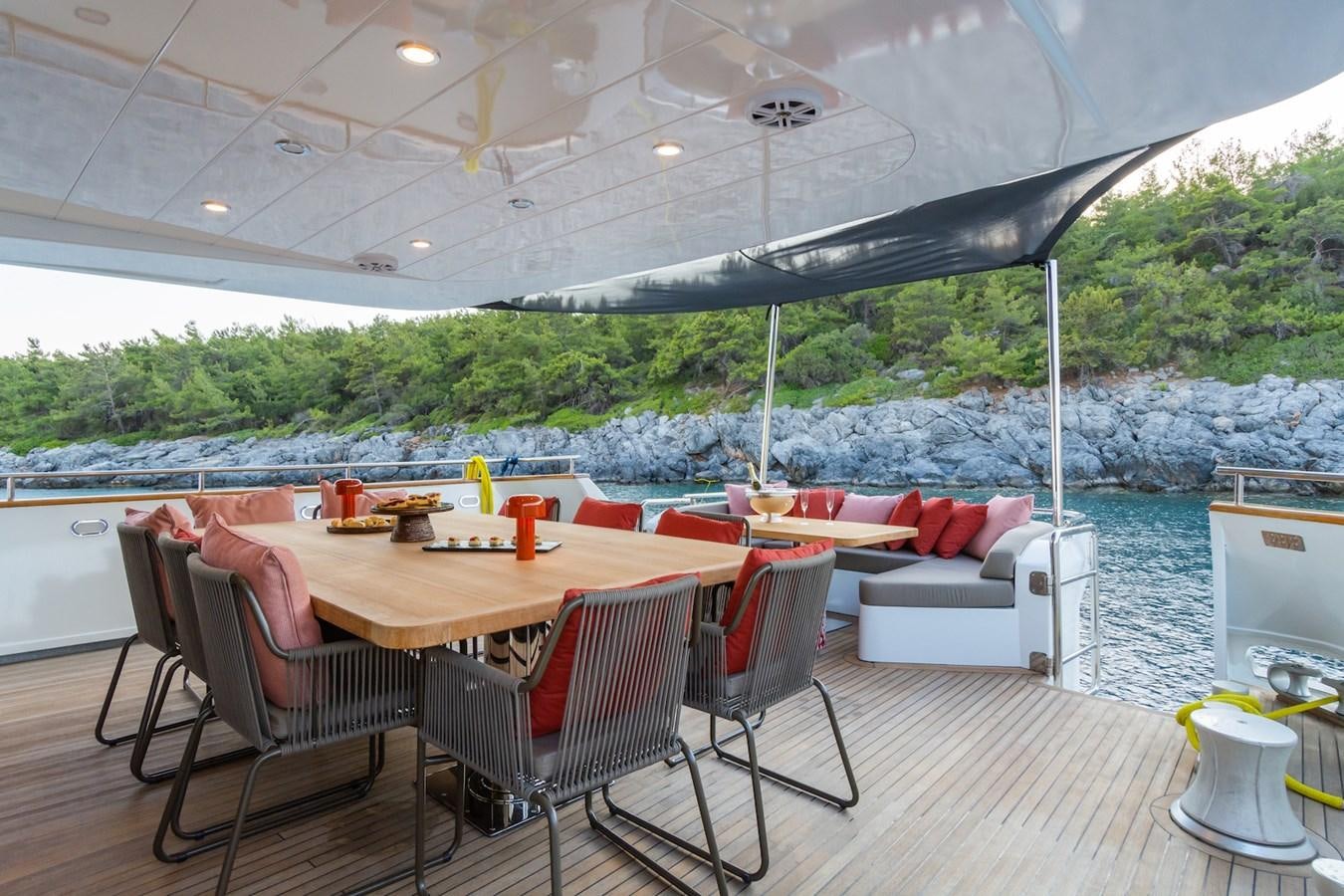 a table and chairs on a deck aboard AXELLA Yacht for Sale