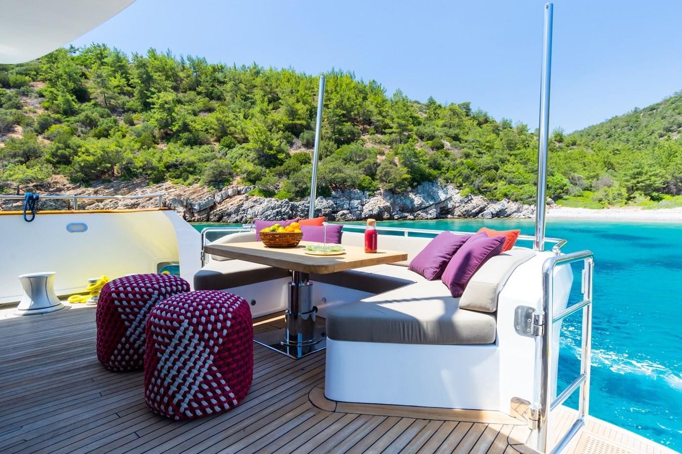 a table and chairs on a deck overlooking a body of water aboard AXELLA Yacht for Sale