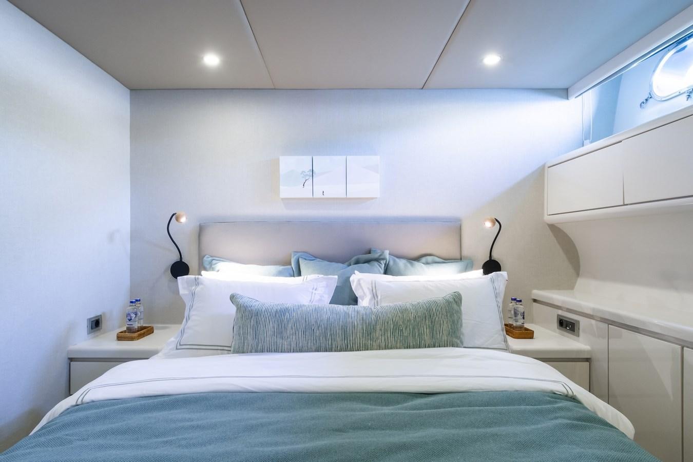 a bed with a blue comforter aboard AXELLA Yacht for Sale