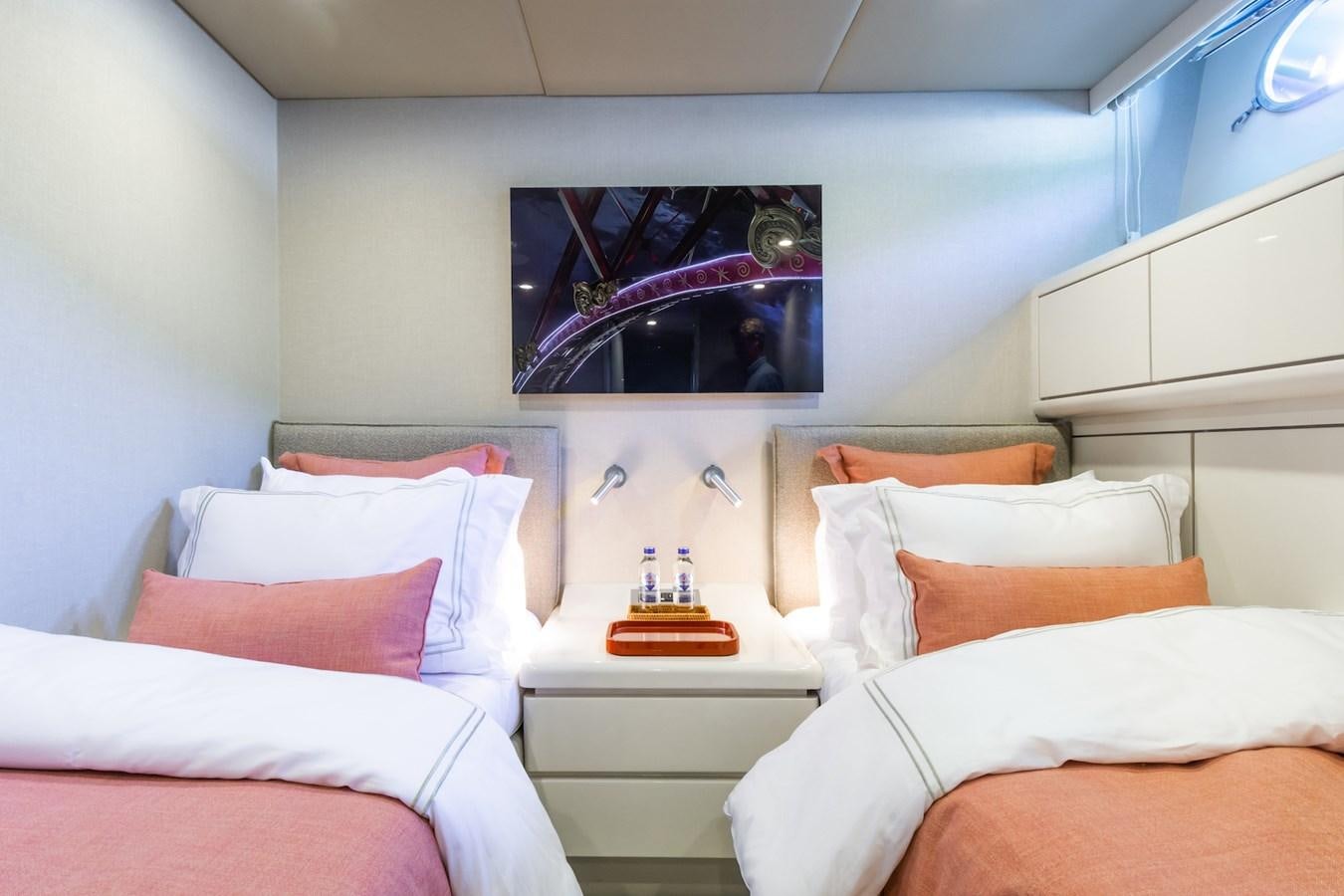 a room with a bed and a television on the wall aboard AXELLA Yacht for Sale