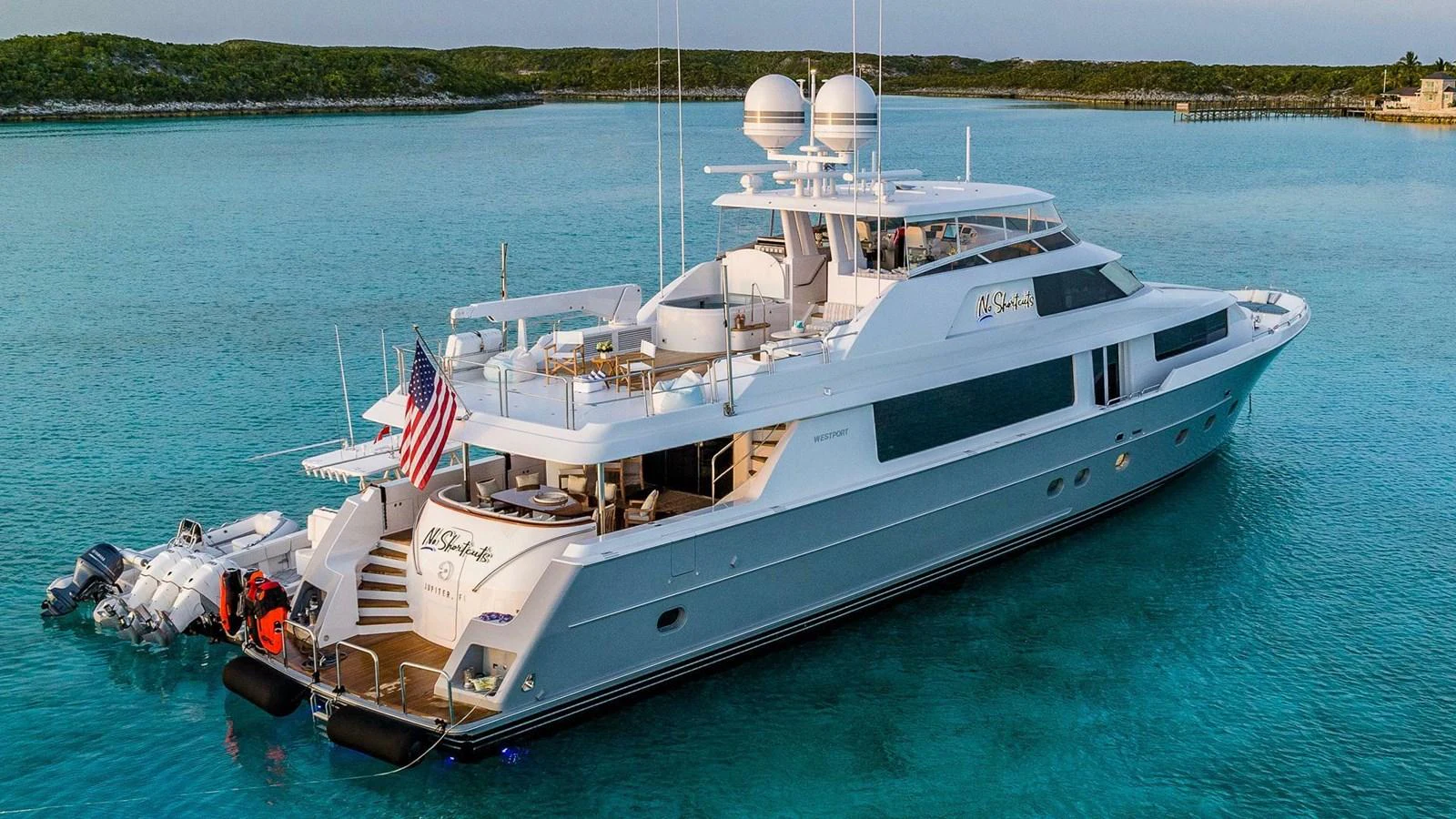 a large white boat with flags on it aboard NO SHORTCUTS Yacht for Sale