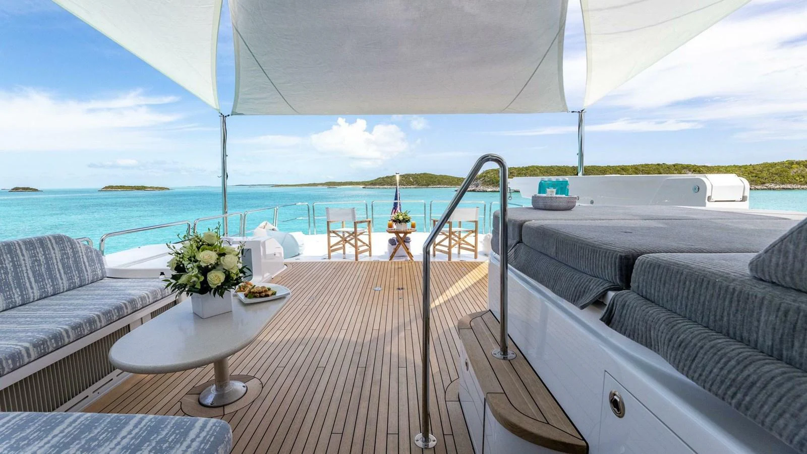 a balcony with a table and chairs aboard NO SHORTCUTS Yacht for Sale