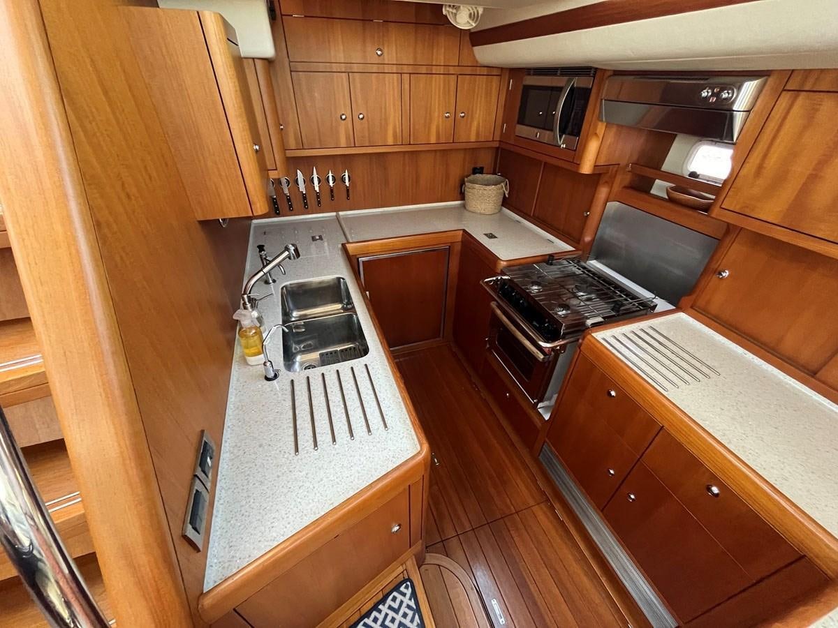 a kitchen with wooden cabinets aboard WEATHERLY Yacht for Sale