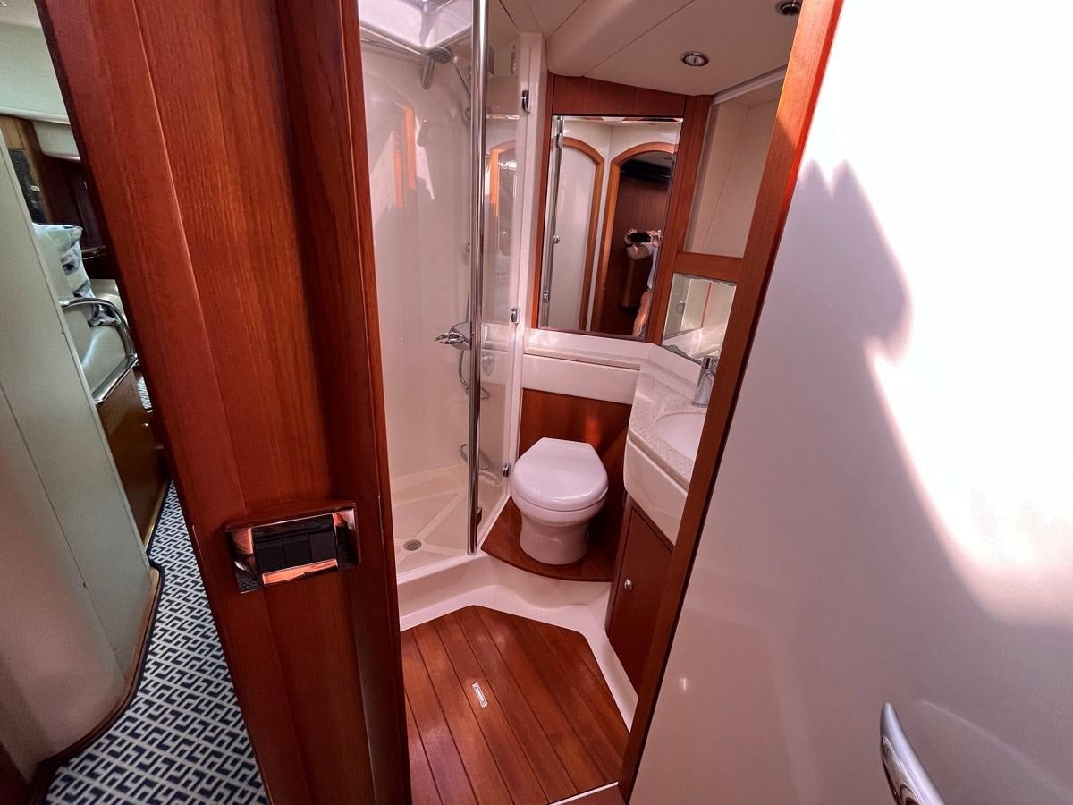 a bathroom with a toilet and a mirror aboard WEATHERLY Yacht for Sale