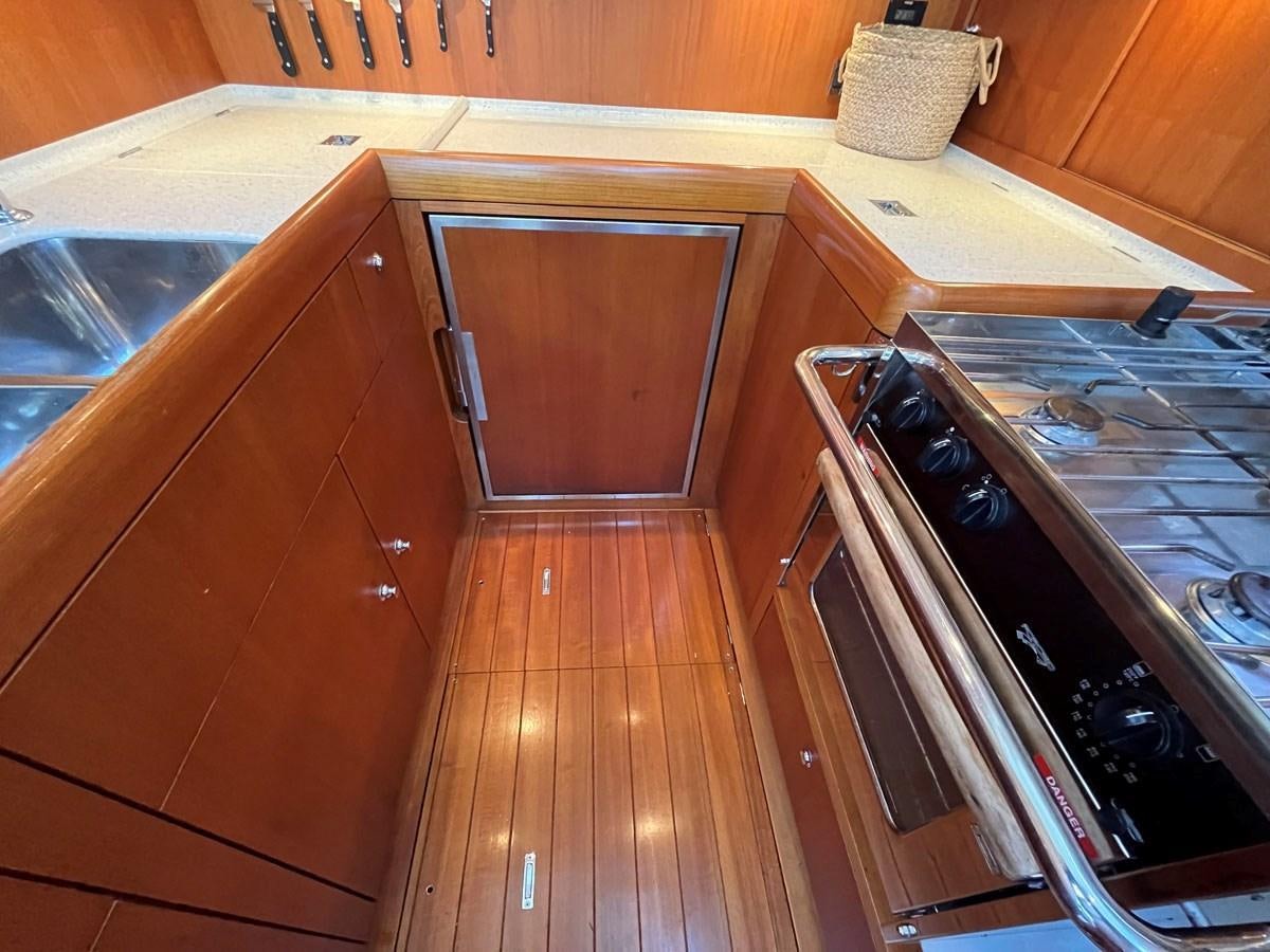 a kitchen with wooden cabinets aboard WEATHERLY Yacht for Sale