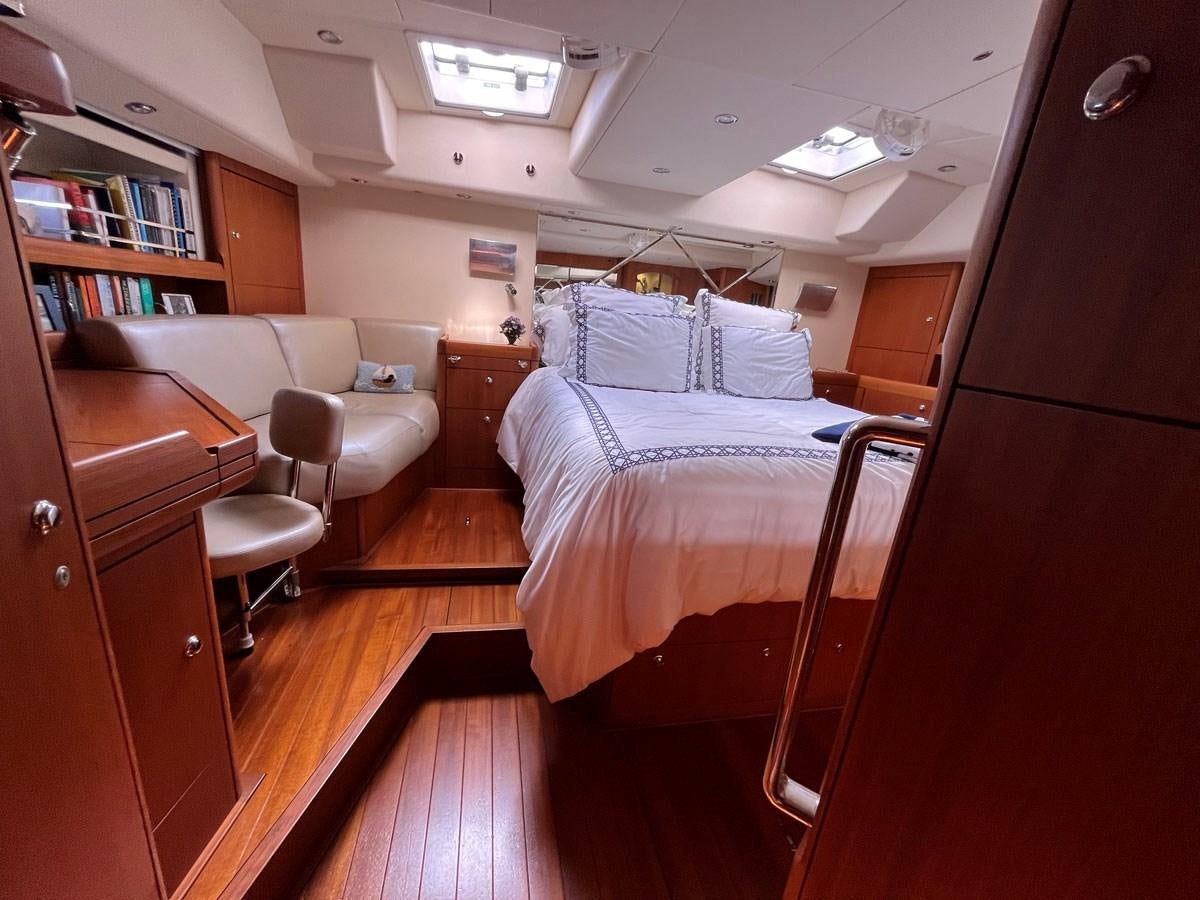 a bedroom with a bed and a desk aboard WEATHERLY Yacht for Sale