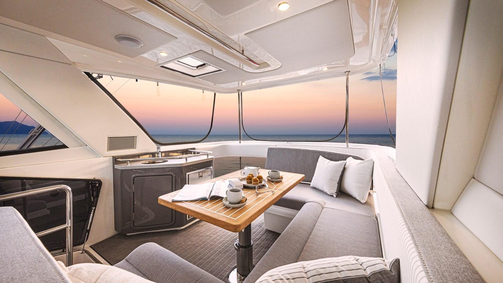 a room with a table and couch aboard 72 SPORTS MOTOR YACHT Yacht for Sale