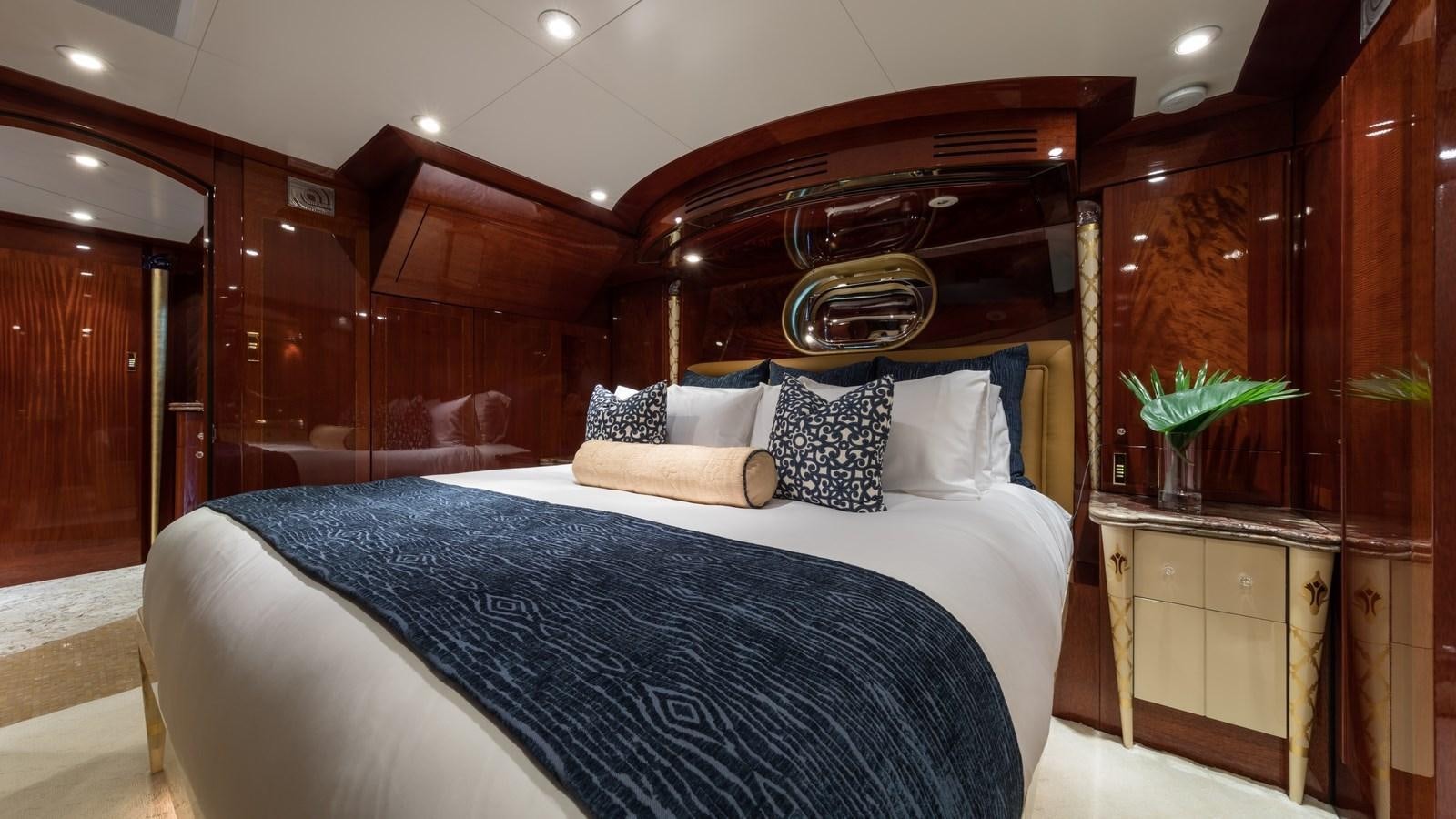 a bed with a blue comforter aboard TOUCH Yacht for Sale